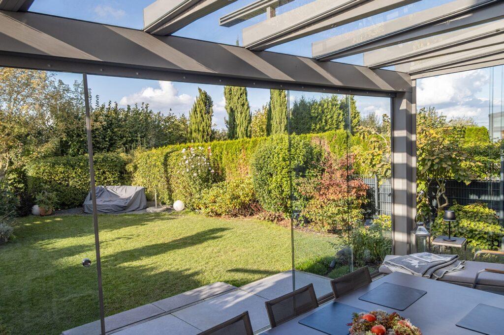 binnen naar buiten overgang met tuinkamer aanbouw en grote glazen schuifwanden