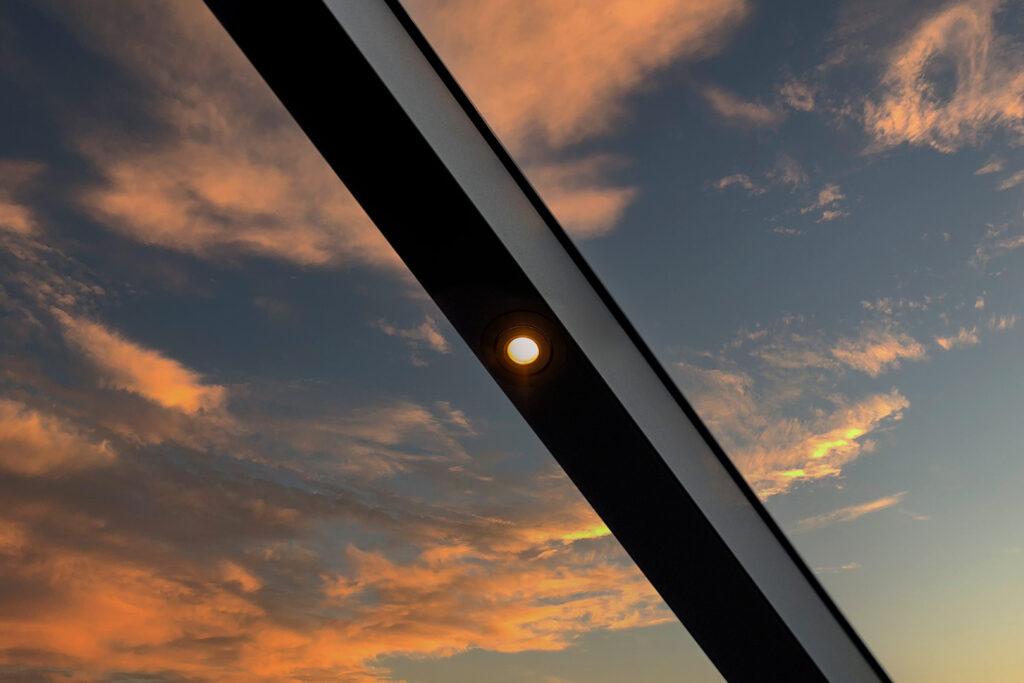 Verlichte aluminium overkapping met sfeervolle LED-verlichting in de avond